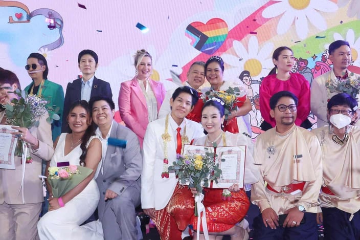 Tinder CMO Melissa Hobley posing for pictures with LGBTQ couples in Bangkok