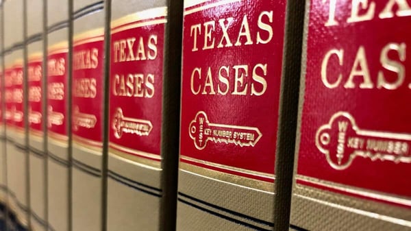 Close-up of red Texas legal case volumes lined up on a shelf behind vertical bars, symbolizing court rulings, legal challenges, and regulatory oversight in Texas. Close-up of red Texas legal case volumes lined up on a shelf behind vertical bars, symbolizing court rulings, legal challenges, and regulatory oversight in Texas.