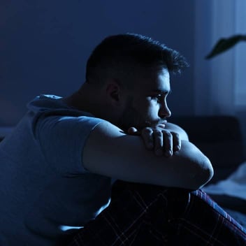 A man sitting alone in the dark A man sitting alone in the dark