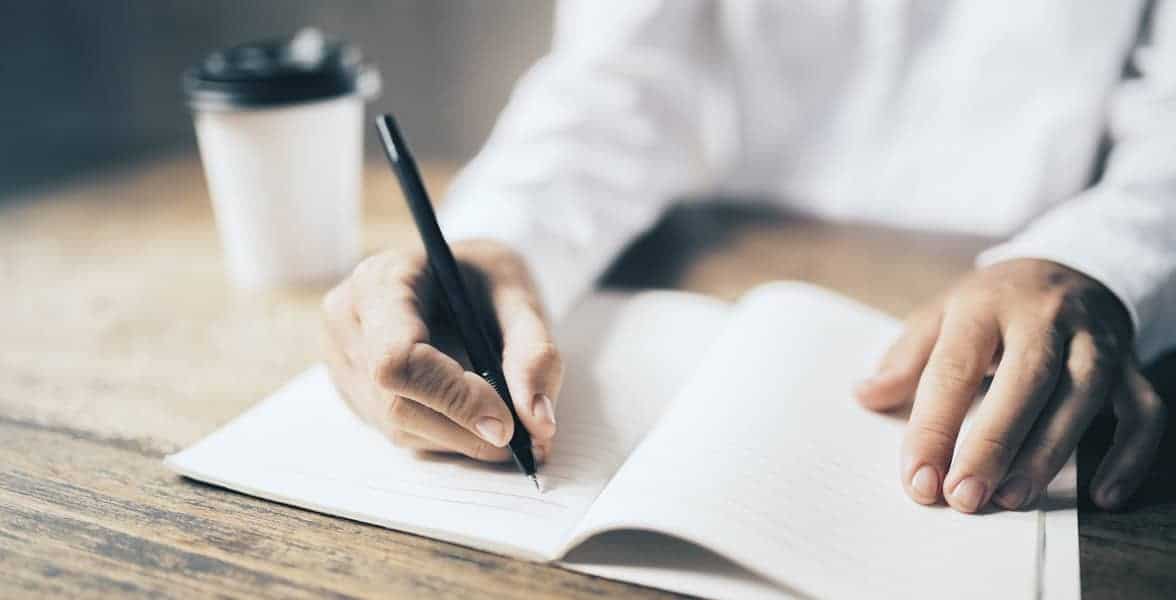 Photo of a man writing Photo of a man writing