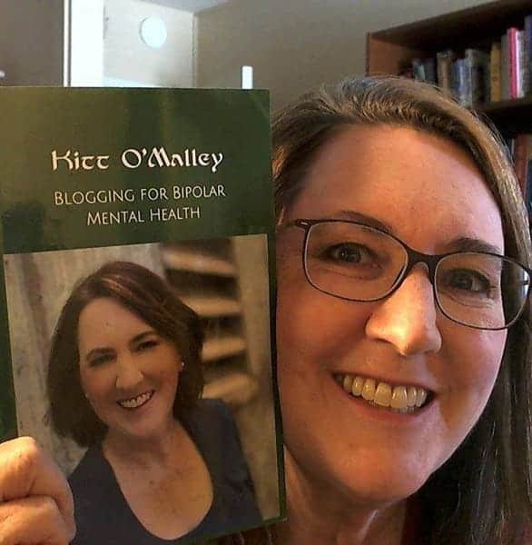 Photo of Kitt O'Malley with her book Photo of Kitt O'Malley with her book